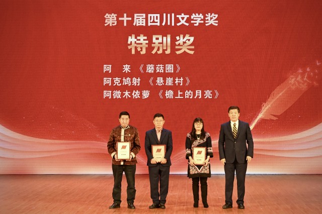 1011028124819938.jpg 四川省政府副省长罗强(右一)与四川文学奖特别奖获得者阿克鸠射(左)、阿来(中)、阿微木依萝(右二)在颁奖台上合影留念.JPG